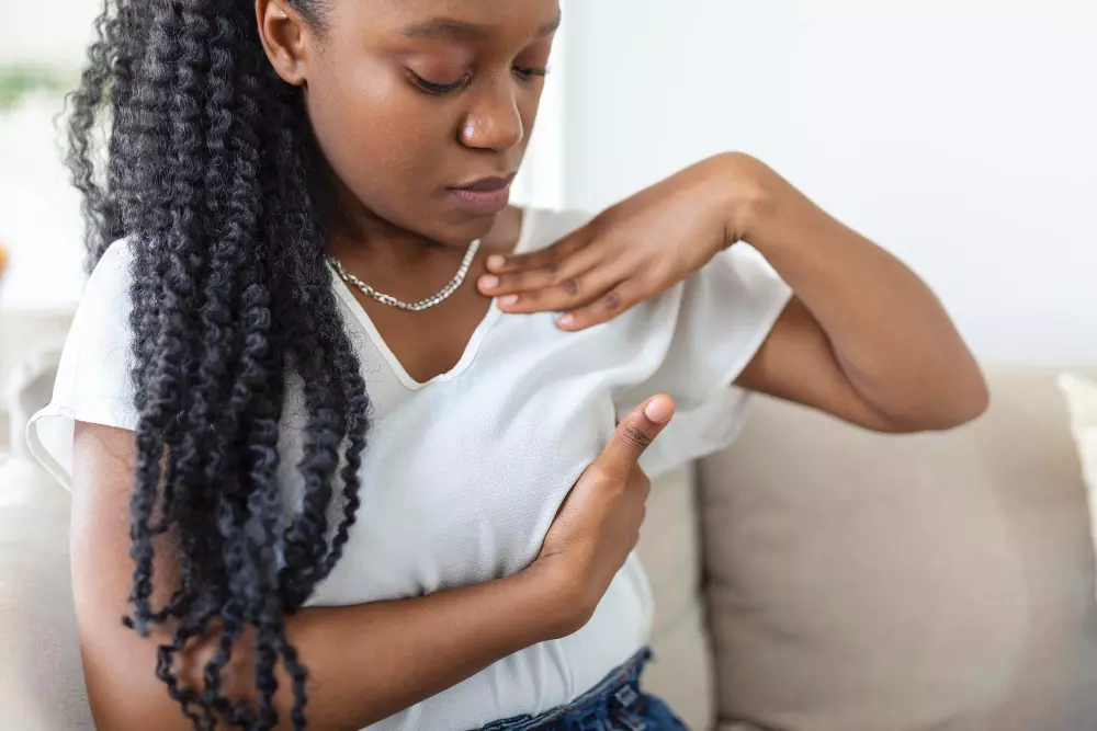Femme pratiquant l'auto-palpation des seins, guide de la Clinique La Noël