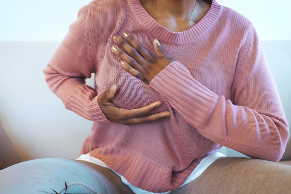 Jeune femme afro palpant sa poitrine