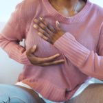 Jeune femme afro palpant sa poitrine